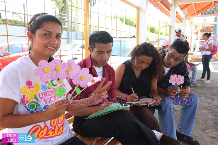 Promotores Solidarios entregan flores y tarjetas a mujeres en paradas de buses