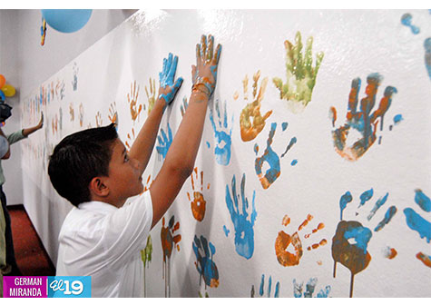 Niños y adultos mayores perennizan manos en pared de huellas de Acahualinca